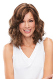 Smiling woman with thinning hair wearing the Mila Wavy Shoulder Length Wig