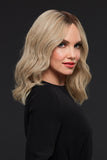 Lady with fine hair wearing a Gwyneth wig in a light blonde shade with dark roots 