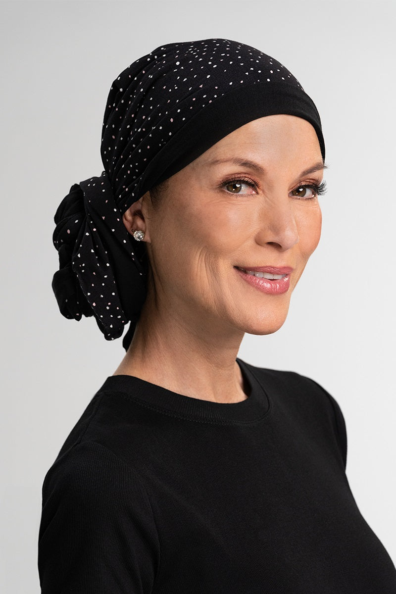 Lady with total hair loss wearing her black printed Reversible Softie Wrap by Jon Renau 