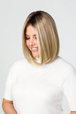 Smiling woman with fine shoulder length blonde hair wearing the Easipart Medium 12 Inch Topper 